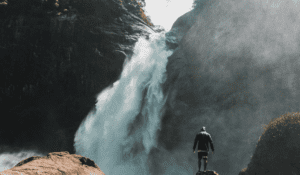 man standing in front of a large waterfall