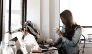 Female working on laptop drinking coffee at home