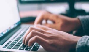 close up of person typing on laptop computer