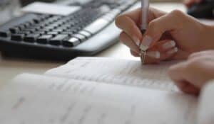hands writing in a journal