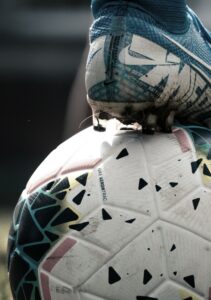 tinted photo of a foot resting on a soccer ball
