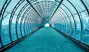 a long glass tunnel with an inlaid stone walkway