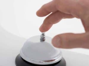 closeup of hand ringing desk bell